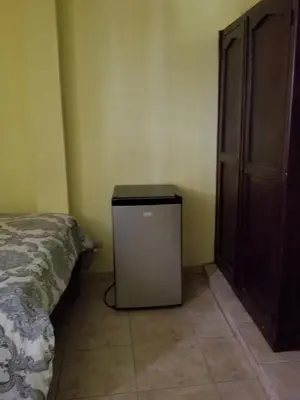 a bedroom with a bed and a small cabinet at Hotel Victoriano in San Felipe de Puerto Plata