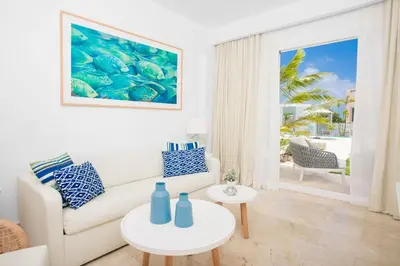 a living room with a couch and a table at Apartamento Acceso Directo a la piscina A-108, A-120, A-117 y B-137 in Punta Cana