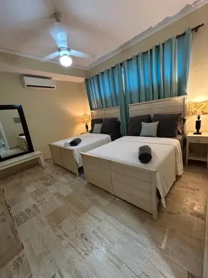 a bedroom with two beds and a sink and a mirror at Best ocean view Sosua-Cabarete in Sosúa