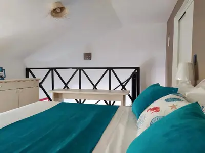 a bedroom with a bed with blue sheets and a bench at Ballenas beach C6 in Las Terrenas