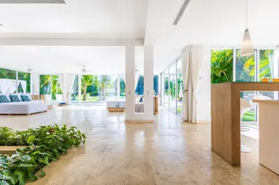 a living room with glass doors and plants at Luxury Rentals in Punta Cana - Exclusive Waterfall Villa with Private Pool, BBQ, Maid, Golf in Punta Cana