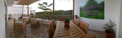 a restaurant with wooden tables and chairs and a balcony at Saman Terrace in Las Terrenas