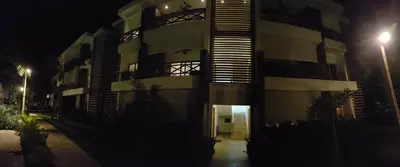 a large building at night with a hallway leading to it at Saman Terrace in Las Terrenas