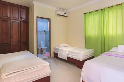 a bedroom with two beds and a green curtain at 1 Bedroom Apartment -Corales del Sur Ole Las Americas- Isabelita - Aeropuerto in La Viva