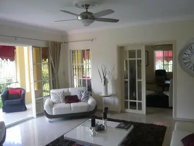 a living room with a couch and a table at Villa Los Almendros - 2 private pools tennis pickle ball in Baní