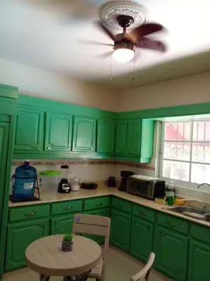 a green kitchen with a table and a ceiling fan at Villa Los Almendros - 2 private pools tennis pickle ball in Baní