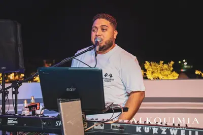 a man speaking into a microphone in front of a laptop at HOTEL ALKQUIMIA in Bayahibe