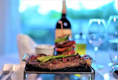 a grill with meat and vegetables and a bottle of wine at HOTEL ALKQUIMIA in Bayahibe
