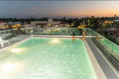 a woman and a child in a swimming pool at night at HOTEL ALKQUIMIA in Bayahibe