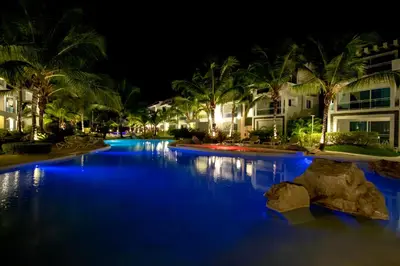 a swimming pool at night with blue lights at Atmospheric apartment with a beautiful view of the swimming pool in Bayahibe