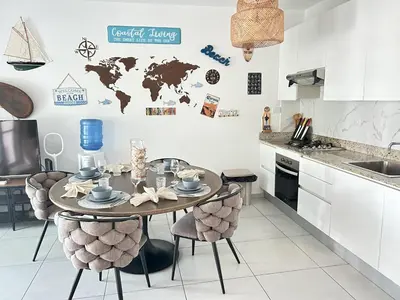 a kitchen with a table and chairs with a world map on the wall at Atmospheric apartment with a beautiful view of the swimming pool in Bayahibe