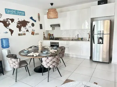 a kitchen with a table and a refrigerator at Atmospheric apartment with a beautiful view of the swimming pool in Bayahibe