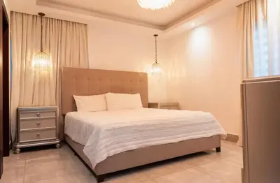 a bedroom with a large bed with white sheets at Amazing Rooftop and Best View of the City in Santiago de los Caballeros