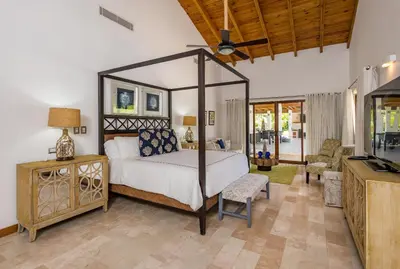 a bedroom with a canopy bed and a living room at Stunning Villa with Private Pool and Jacuzzi in Casa de Campo in La Romana