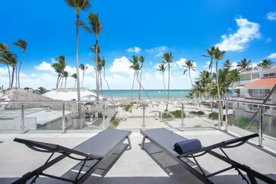 a patio with a table and chairs and the beach at Luxury Villa in Bávaro Just on the Beach in Punta Cana