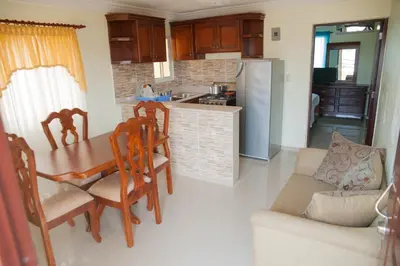 a kitchen and dining room with a table and chairs at Modern 1-Bedroom Apartment with Terrace 300 Mbps Wi-Fi Near SDQ Airport in La Viva