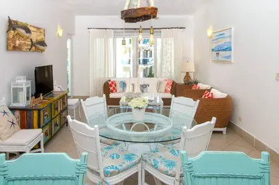 a living room with a glass table and chairs at Palmeraie Terrenas beach apartamento in Las Terrenas