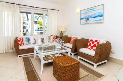 a living room with wicker chairs and a table at Palmeraie Terrenas beach apartamento in Las Terrenas