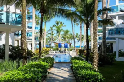 a view of a resort with palm trees and a swimming pool at Palmeraie Terrenas beach apartamento in Las Terrenas