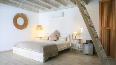 a bedroom with a bed and a table and a mirror at TAKUMA BOUTIK HOTEL in Las Terrenas