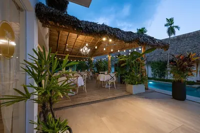 a restaurant with a table and chairs on a deck at TAKUMA BOUTIK HOTEL in Las Terrenas