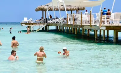 a group of people in the water near a pier at 3BR Apt @CadaquesCaribe Bayahibe in San Rafael del Yuma