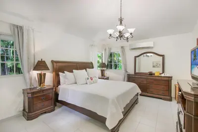 a bedroom with a bed and two dressers and a mirror at Amazing Villa in Casa de Campo with Included in Price Maid and Waiter in La Romana