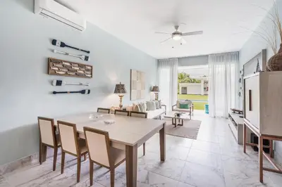 a dining room and living room with a table and chairs at Playa Bonita Amazing Condo at Lake View in La Ceiba