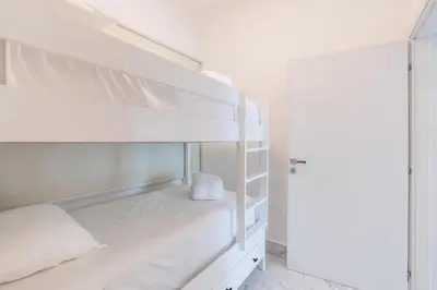 a white bunk bed in a white room at Playa Bonita Amazing Condo at Lake View in La Ceiba