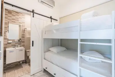 a bedroom with a bunk bed and a bathroom at Playa Bonita Amazing Condo at Lake View in La Ceiba