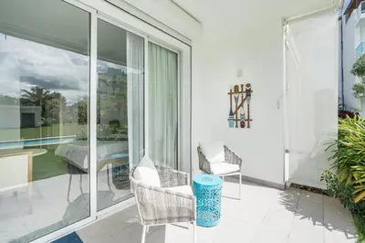 a patio with glass doors and a table and chairs at Playa Bonita Amazing Condo at Lake View in La Ceiba