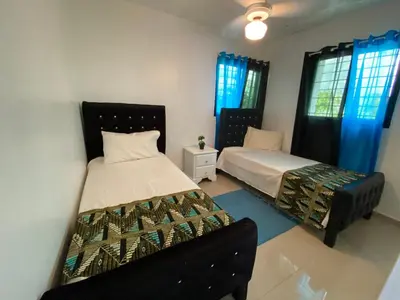 a bedroom with two beds and a couch in it at Santiago City Center Huge nice Apartment to stay rooftop to enjoy the city view in Santiago de los Caballeros