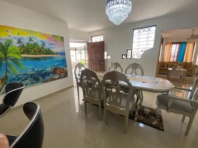 a dining room with a table and chairs and a painting at Santiago City Center Huge nice Apartment to stay rooftop to enjoy the city view in Santiago de los Caballeros