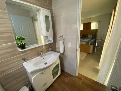 a bathroom with a white sink and a mirror at Santiago City Center Huge nice Apartment to stay rooftop to enjoy the city view in Santiago de los Caballeros