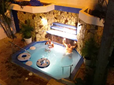 two men are in a swimming pool at Hotel Caribe in Santa Cruz de Barahona