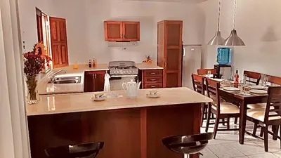 a kitchen with an island in a kitchen with a table at Colina Buena vista A4 in Jarabacoa