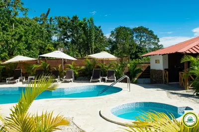 a pool with chairs and umbrellas at a resort at Colina Buena vista A4 in Jarabacoa