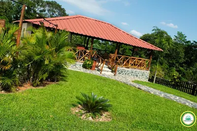 a building with a red roof and a grass yard at Colina Buena vista A4 in Jarabacoa