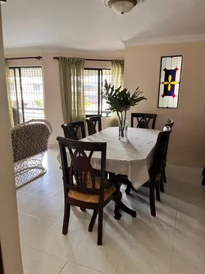 a dining room with a white table and chairs at Apartamento amueblado en Villa Olga in Santiago de los Caballeros