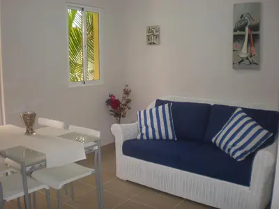 a living room with a blue couch and a table at Vanilla House in Bayahibe