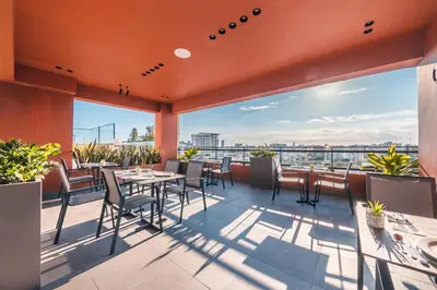 a patio with tables and chairs on a roof at Fully Serviced Apartment at Regatta Living - 2C in Santo Domingo