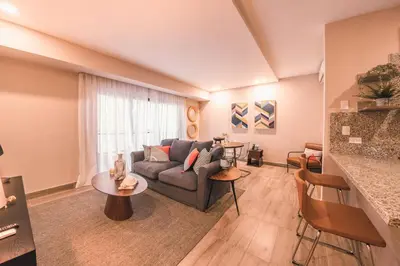 a living room with a couch and a table at Fully Serviced Apartment at Regatta Living - 2C in Santo Domingo