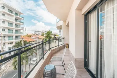 a balcony with two chairs and a view of a city at Fully Serviced Apartment at Regatta Living - 3B in Santo Domingo