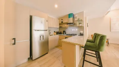 a kitchen with a refrigerator and a counter at Fully Serviced Apartment at Regatta Living II - 703 in La Julia