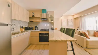 a small kitchen with a counter and a table at Fully Serviced Apartment at Regatta Living II - 703 in La Julia