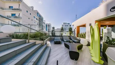 a balcony with couches and chairs on a building at Fully Serviced Apartment at Regatta Living II - 703 in La Julia