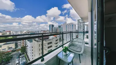 a balcony with two chairs and a view of a city at Fully Serviced Apartment at Regatta Living - 9F in Santo Domingo