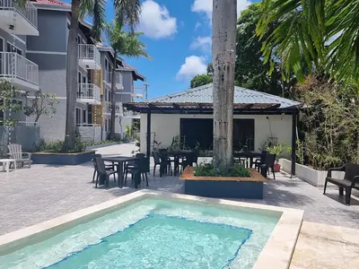 a swimming pool in a courtyard with a table and chairs at Hotel Sea Breeze Sosua in Sosúa