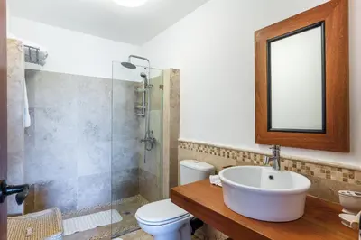 a bathroom with a sink and a toilet and a mirror at The Greatest 3BR Villa at Puerto Bahia in Los Grini