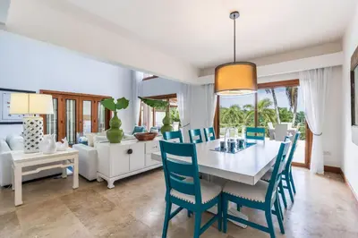 a dining room with a white table and blue chairs at The Greatest 3BR Villa at Puerto Bahia in Los Grini
